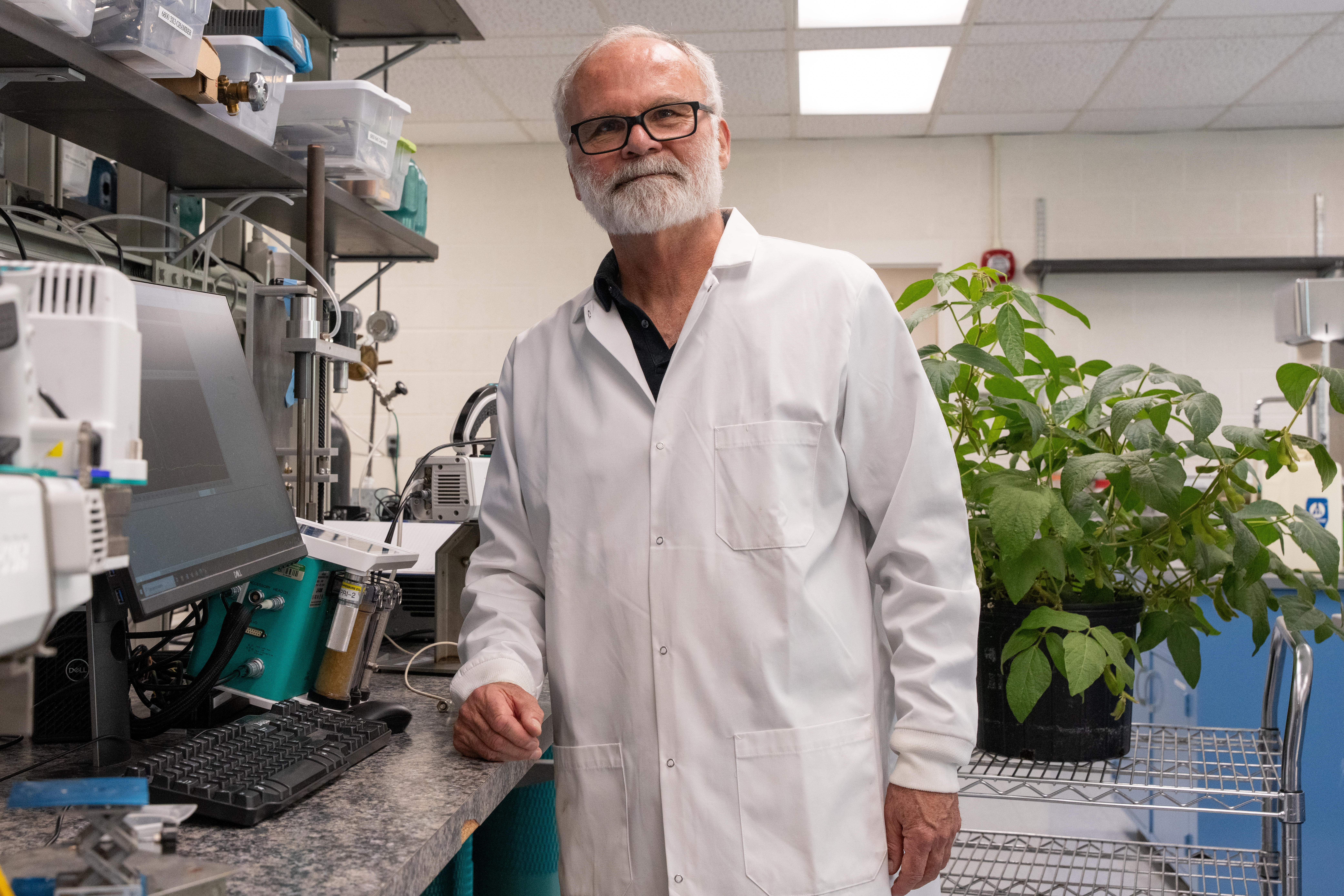 Photo of Thomas Sharkey in a lab setting with plants in the background
