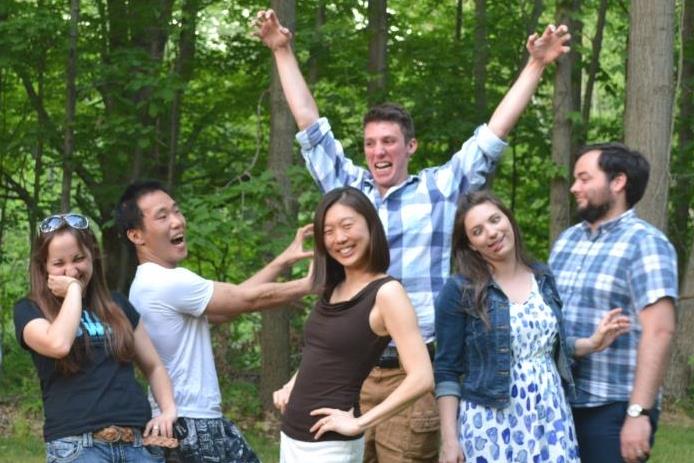 Group photo of the Lunt lab making funny faces and gestures at a summer BBQ 2