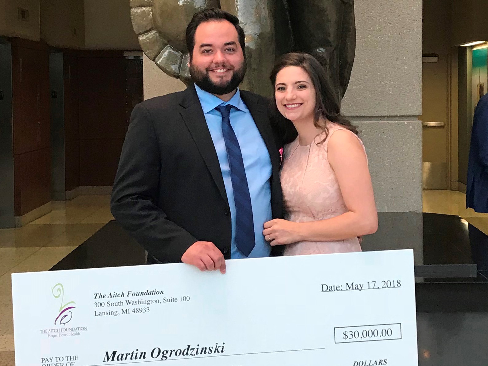 Martin and Allie Ogrodzinski holding giant check