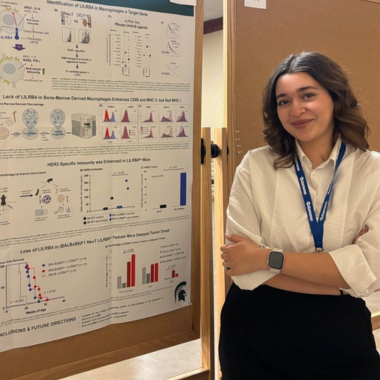 Photo of Graduate student Sarah Marei poses during a poster session.