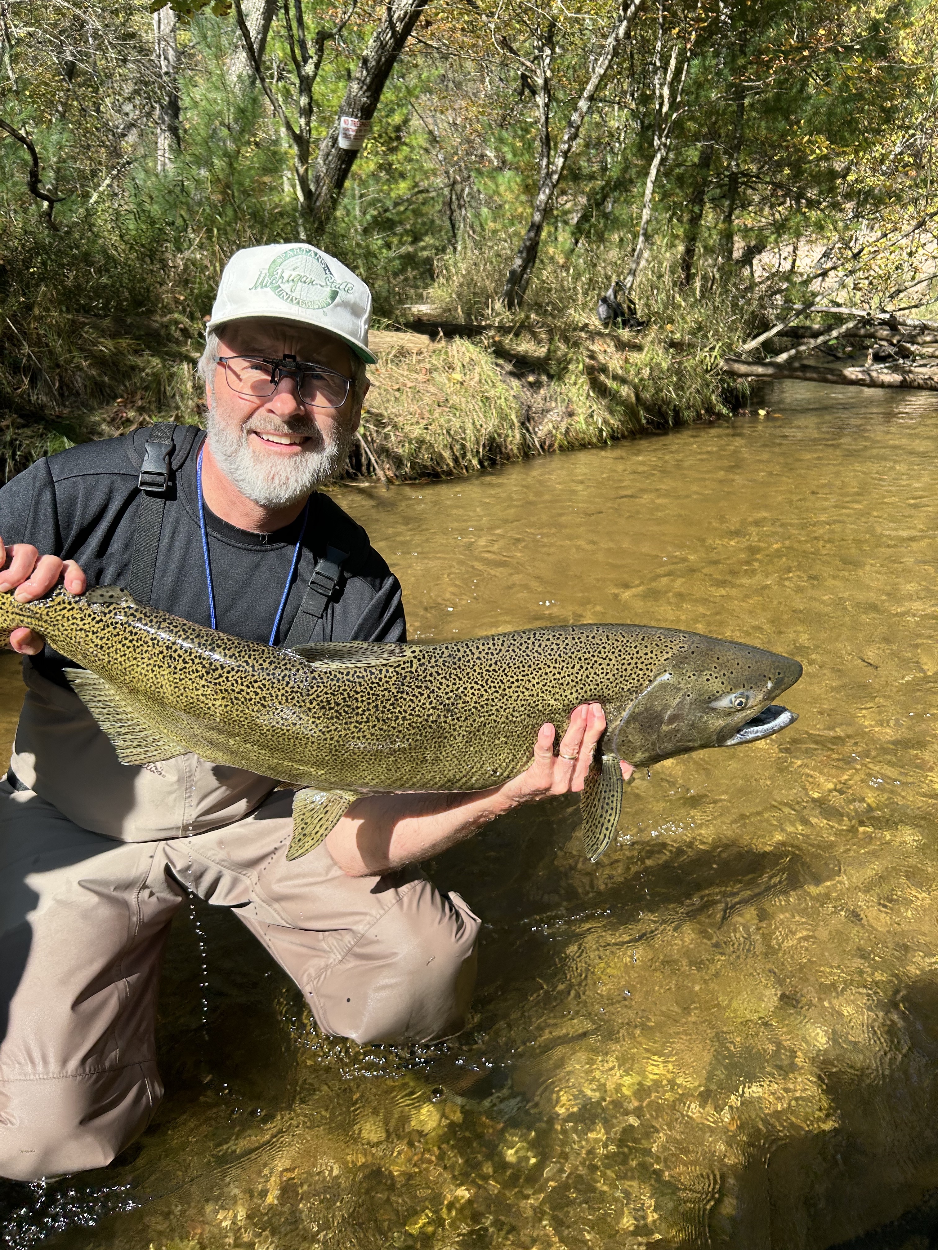 Dr. Lee Kroos with a large salmon in a Northern Michigan river